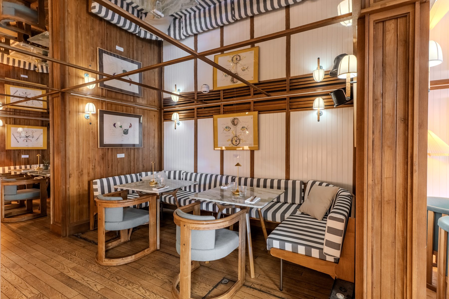 Stars of Monaco — striped booth with marble table and framed illustrations