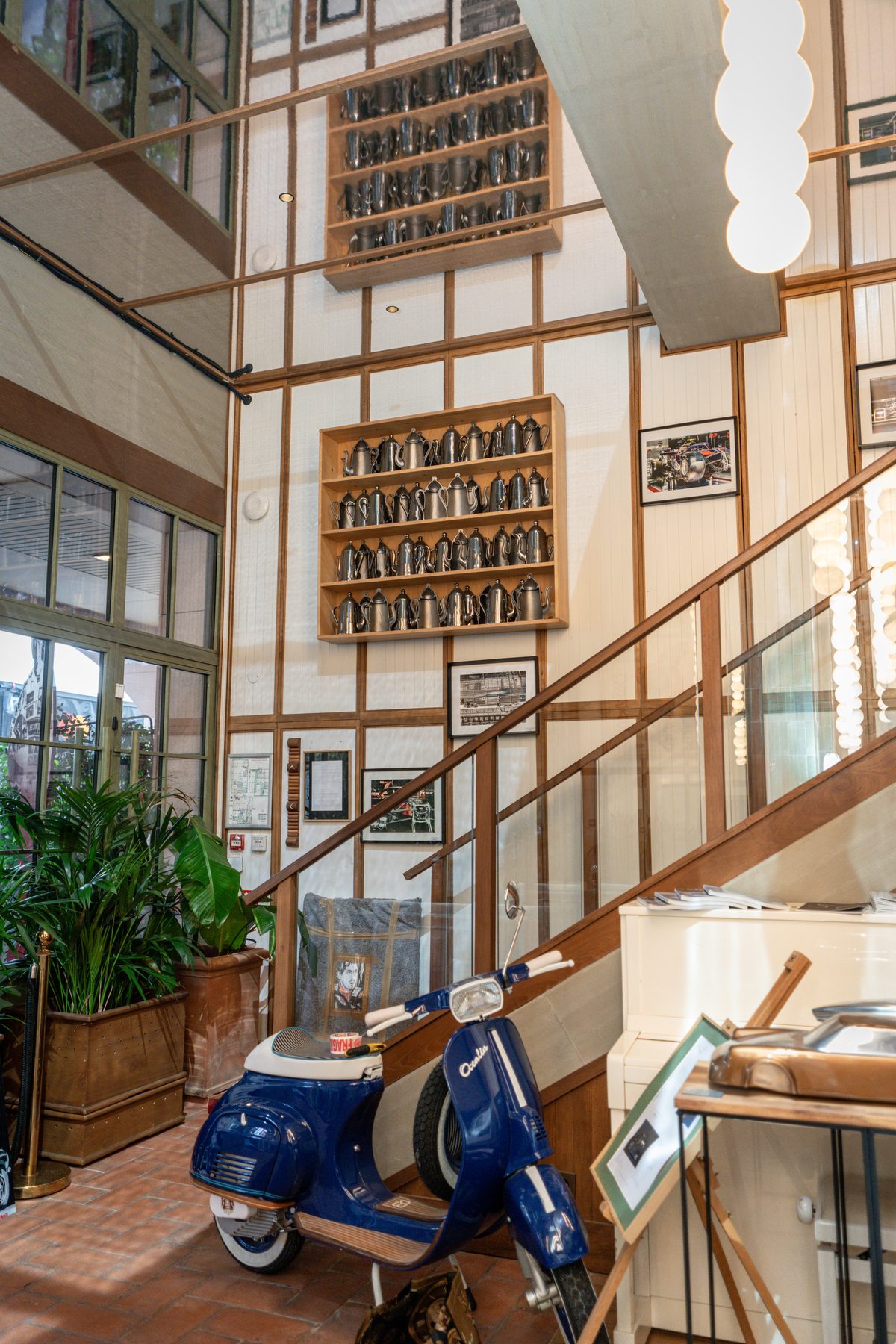 Stars of Monaco — stairwell with vintage Vespa and memorabilia wall