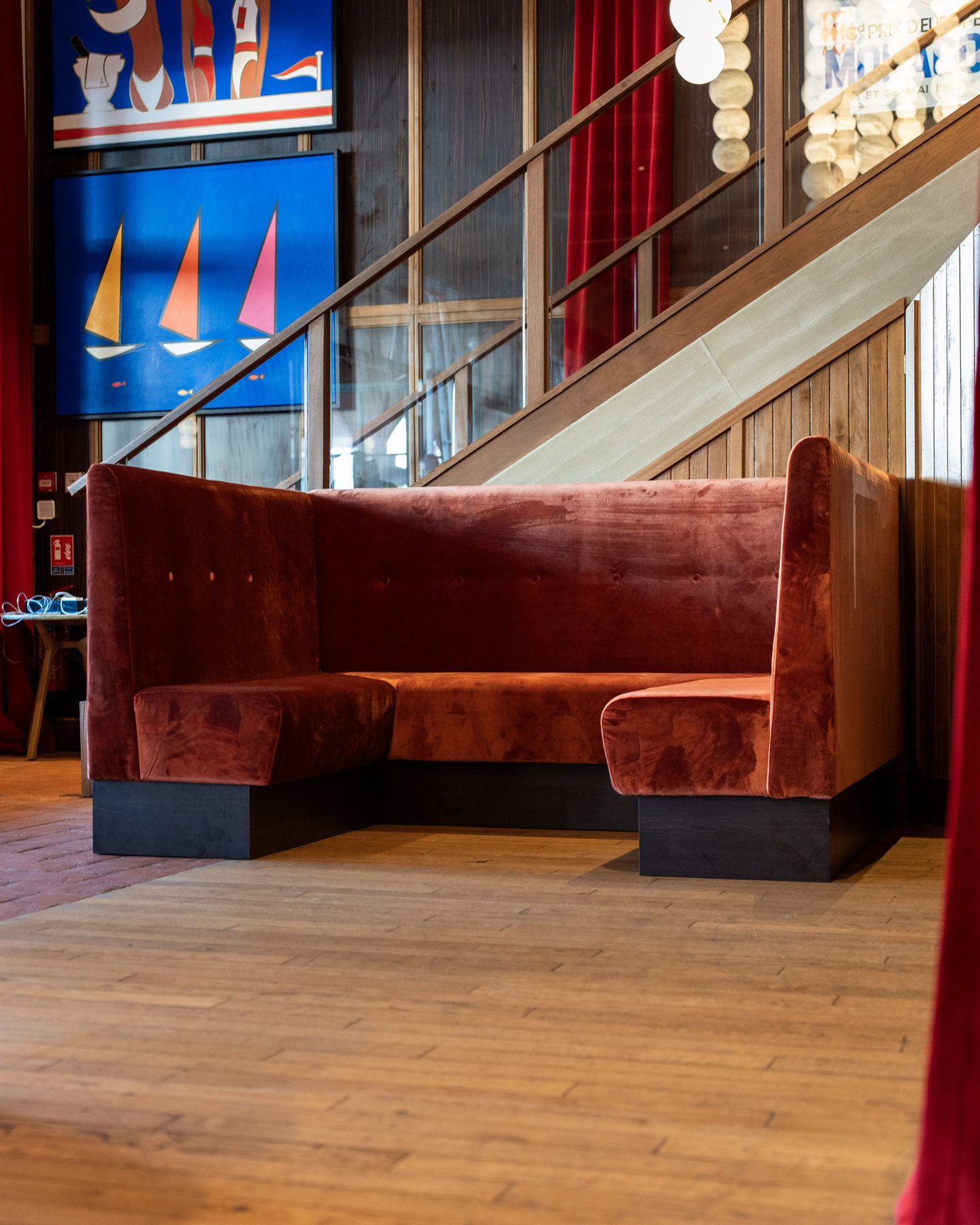 Stars of Monaco — banquette en velours rouge et œuvres voiliers