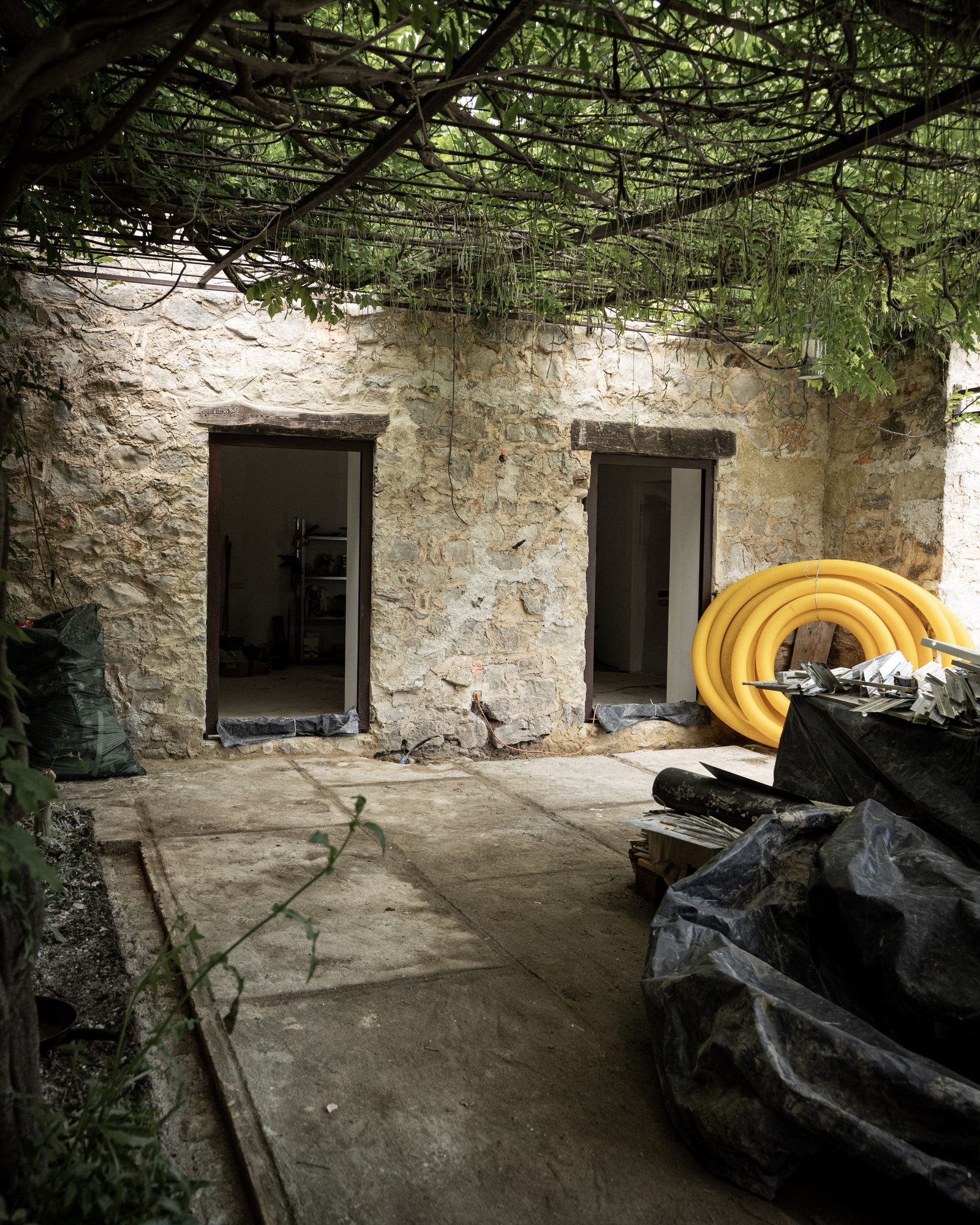 Original stone façade with reclaimed sage-green shutters